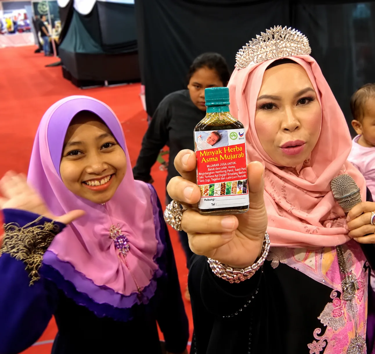 Datuk Vida memegang botol Minyak Herba Asma Mujarab Original dalam sebuah acara